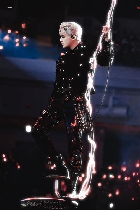 a male in a black outfit is performing on a stage with some lights ...