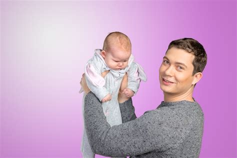 Premium Photo | Happy young man holding a baby