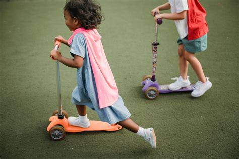 Girl in Pink T-shirt and Blue Denim Shorts Riding Pink Kick Scooter · Free Stock Photo