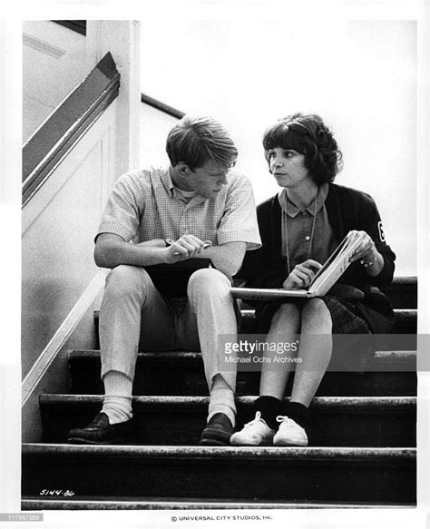 Cindy Williams showing a book to Ron Howard sitting on the stairs in... | American graffiti ...