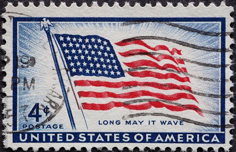 a postage stamp printed in the US showing The First US Flag with old ...