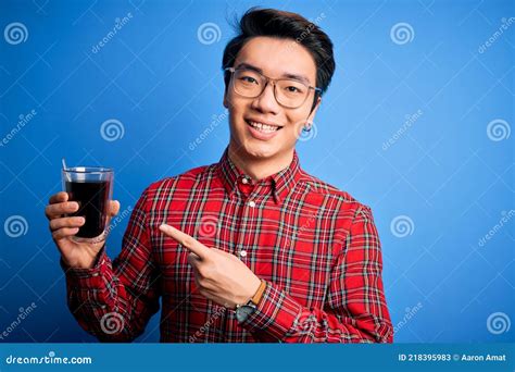 Young Handsome Chinese Man Drinking Glass of Coffee Over Isolated Blue Background Very Happy ...