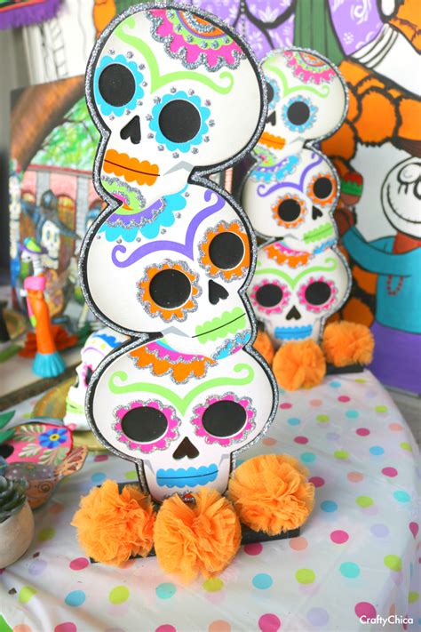 three paper skulls sitting on top of a polka dot table cloth covered ...