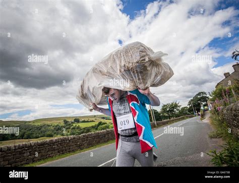 A competitor takes part on the Oxenhope Straw Race in Yorkshire, which involves running in fancy ...