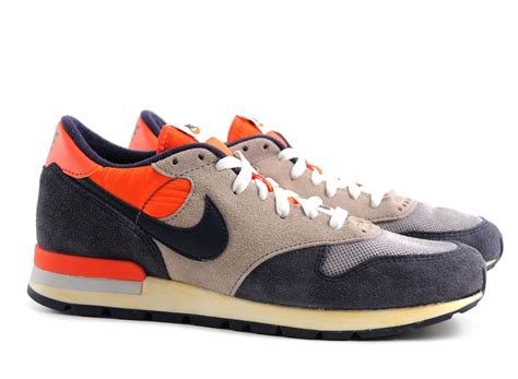 the nike air vortex is in grey and orange