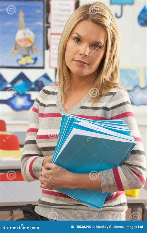 Female Teacher Sitting At Desk In Classroom Stock Photo - Image: 15538390