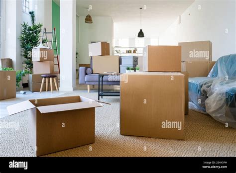 Living room full of cardboard boxes in new loft apartment Stock Photo - Alamy