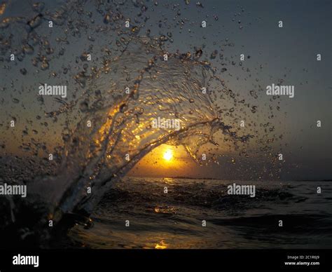 Silhouette of water splash at sunset, next to the sea Stock Photo - Alamy