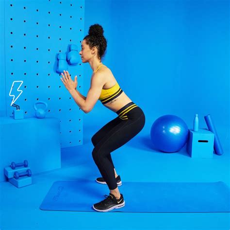 a woman in a yellow top and black leggings is holding a blue ball