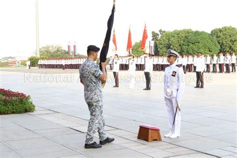 An award recipient with the State Colours at Singapore Armed