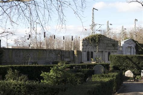 Historic City Graveyard with Family Graves in Front of a Modern Railroad with Signals and ...