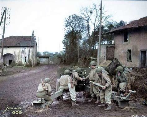 U.S. 607th Tank Destroyer Battalion loading their 3 inch M5 anti-tank gun on a road approaching ...