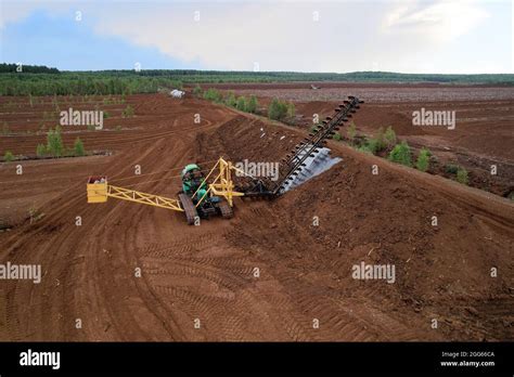 Peat extraction site. Harvester at collecting peat on peatlands. Mining ...