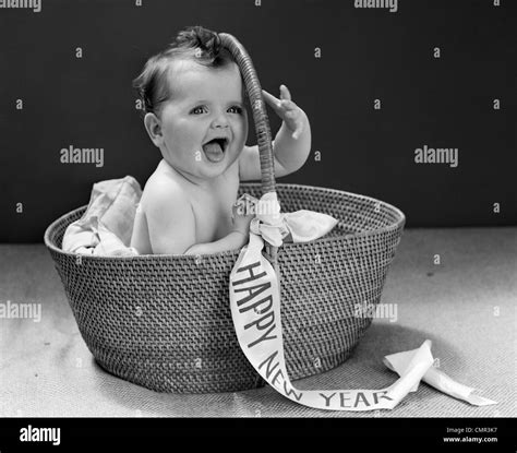 1940s BABY SITTING IN WICKER BASKET WITH HAPPY NEW YEAR BANNER STUDIO INDOOR Stock Photo - Alamy