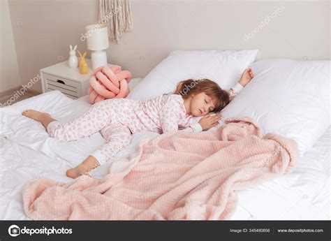 Cute little girl sleeping in bed Stock Photo by ©serezniy 345480856