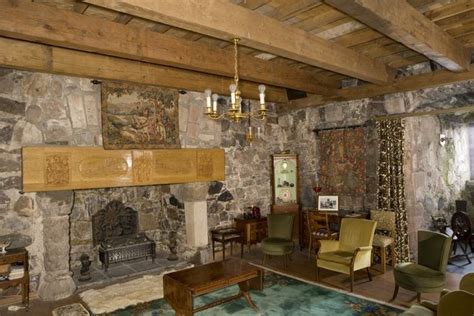 a living room filled with furniture and a fire place next to a wall covered in stone