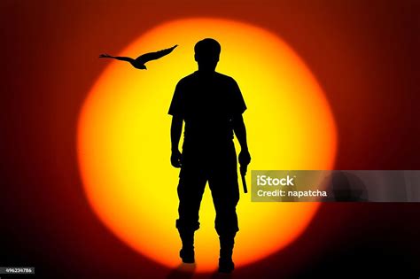 Silhouette Rear Of Man Standing Hand Holding Gun Revolvers Stock Photo - Download Image Now - iStock