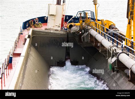 Dredger's split hopper in split open position immediately after emptying it's contents to the ...