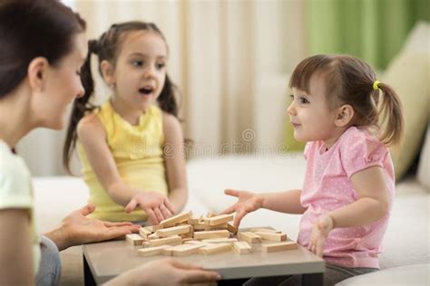 Happy Family Playing Jenga Together at Home. Mother and Daughters Having Fun in Living Room ...