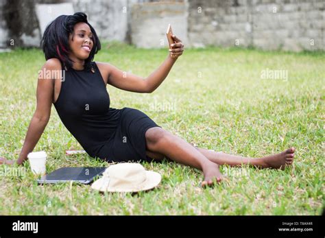 girl sitting alone at the park takes a picture in the park with a smatphone Stock Photo - Alamy