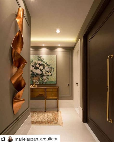 an instagram page with the image of a hallway in brown and gold tones, along with a painting on ...