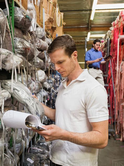 Workers examining fabric in textile factory - Stock Photo - Dissolve