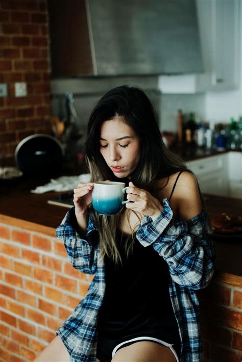 Girl drinking coffee in kitchen - Sinouk Coffee