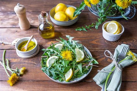 Dandelion Salad with Dip Made with Olive Oil, Lemon Juice and Spices on Brown Wooden Table ...