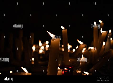 Slow burning wax candles in church as a symbol of death memory. Dark macro close composition ...