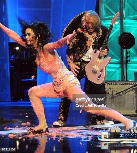 Katy Perry falls after jumping on a cake during her performance at ...