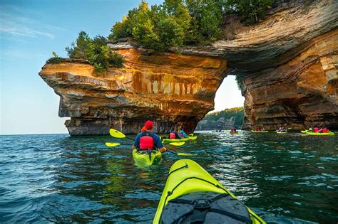 Kayakers paddle near and under Lovers’ Leap. Photo courtesy of Pictured Rocks Kayaking. Kayak ...