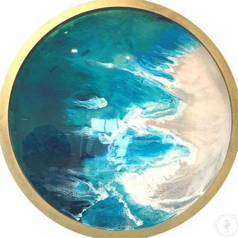 a round glass plate with blue and white paint on it's surface, in gold rim