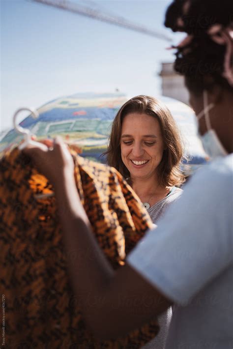 Two friends choosing vintage clothes at the flea market - Stock Image - Everypixel