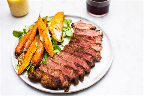 Seared New York Strip Steak Served With Roasted Carrots and Sweet Potatoes and a Warm Maple ...