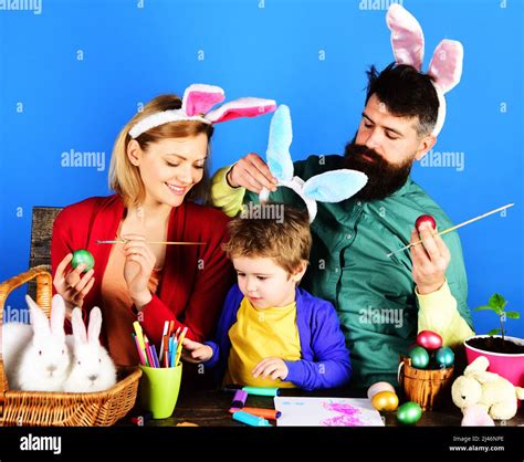 Rabbits family in bunny ears Painting eggs for holiday. Easter egg ...