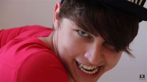 a young man wearing a red shirt and a black hat with the word i love ...