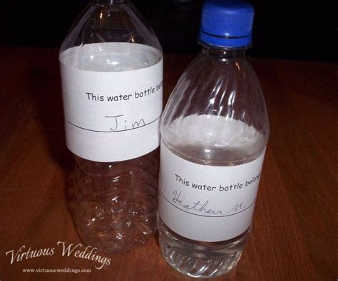 two bottled water bottles sitting on top of a wooden table next to each other with writing on them