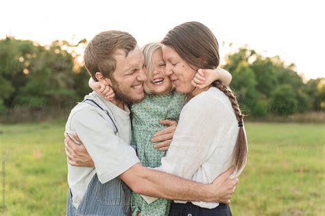 "A Family Of Three In A Group Hug" by Stocksy Contributor "Alison Winterroth" - Stocksy