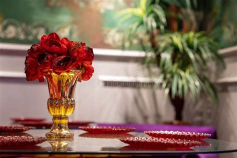 Modern Glass Table Decorated with a Vibrant Golden Vase and Red Flowers Stock Image - Image of ...