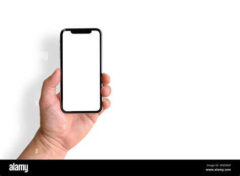 Man holding mobile phone with blank screen on white background, closeup of hand. Space for text ...