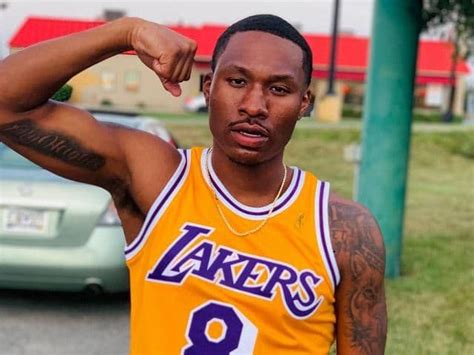 a man in a lakers jersey is posing for the camera with his hand on his head