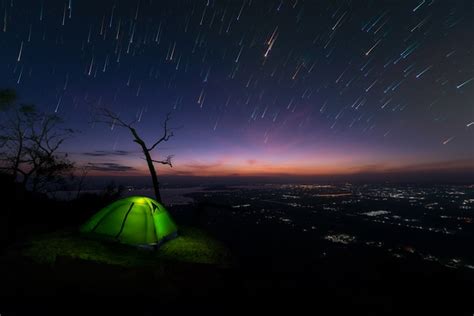 Premium Photo | Camping tent glows on mountain under a night sky ...