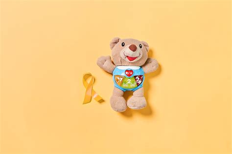 A teddy bear with childhood cancer awareness yellow ribbon. February, 15 - Childhood Cancer Day ...