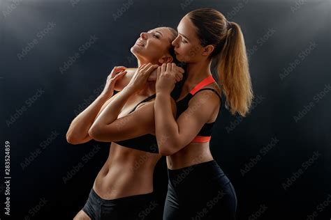 Sexy athletic girl strangles another girl in bra with. Fighting power photo shoot young female ...