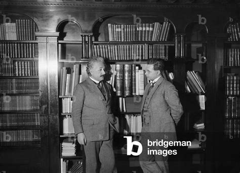 Image of Albert Einstein stands in front of bookshelves with his son by ...