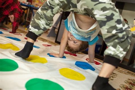 Premium Photo | Child having fun playing twister game at home