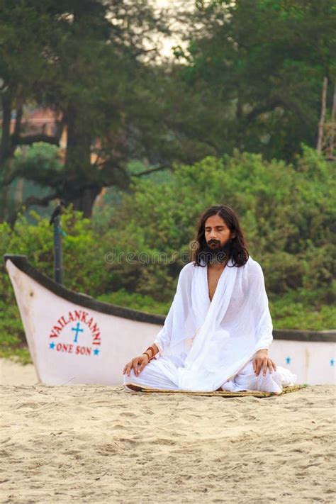 GOA, INDIA - APR. 24, 2014: Man Dressed in White Practices Yoga in ...