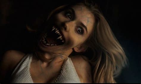 a woman with her mouth open in the dark, showing teeth and fangs on her ...