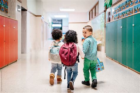 "Happy Kids Walking In School Corridor" by Stocksy Contributor "Sergio Marcos" - Stocksy