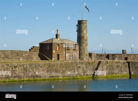 Old quay at Whitehaven harbour, Cumbria UK, with old pier master's house and watch-tower Stock ...